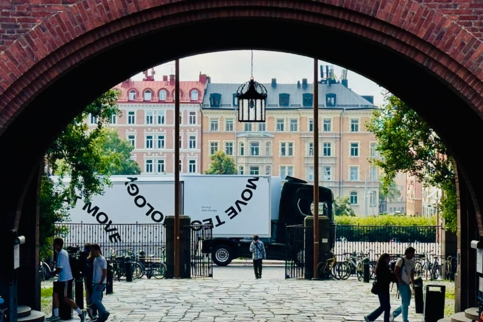 A Scania truck and trailer framed in a brick archway.